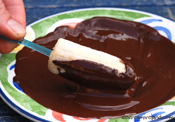 Frozen Banana Pop rolling in chocolate